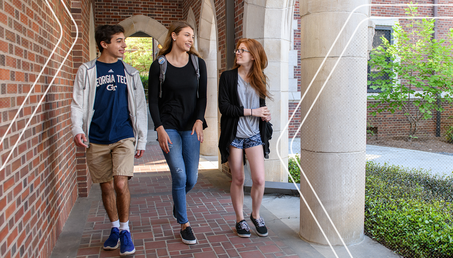 Tech students walking down an outdoor corridor.